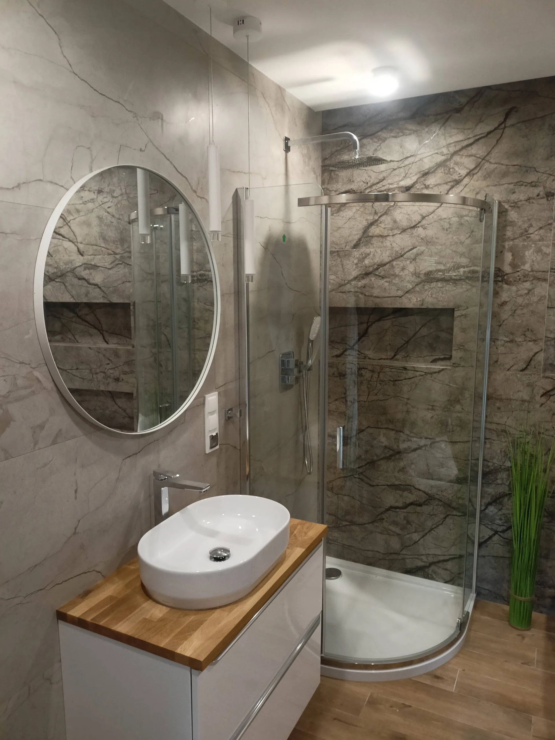 Gotowa łazienka z prysznicem walk-in i jasną okładziną ścienną