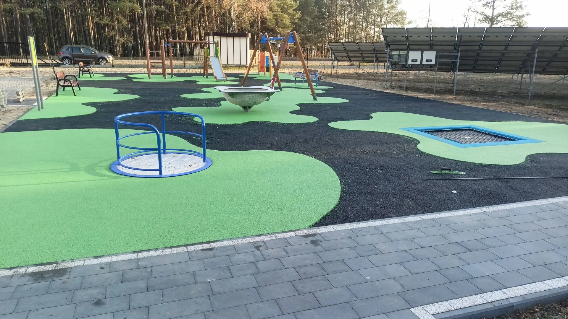 Nowoczesny plac zabaw z nawierzchnią w kolorze zielonym i czarnym