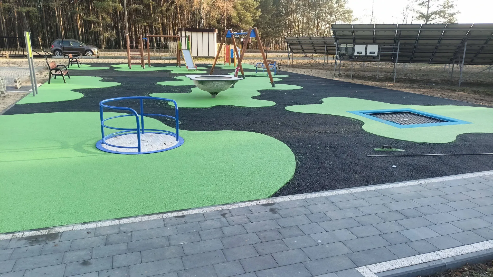Nowoczesny plac zabaw z nawierzchnią w kolorze zielonym i czarnym